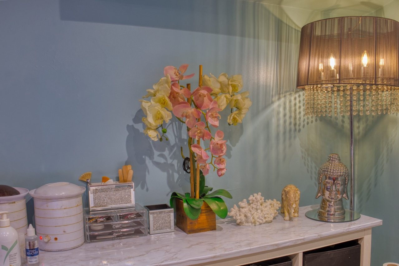 Shelf with orchids and warm lamp inside the salon